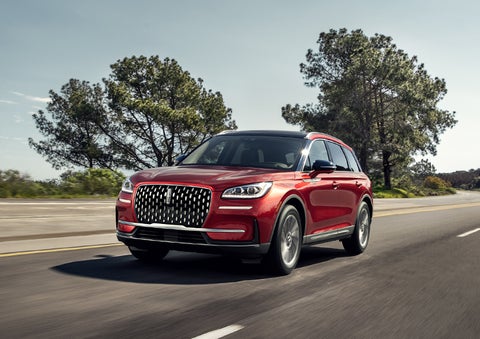A 2024 Lincoln Corsair® SUV is shown being driven on a country road. | Stivers Lincoln in Waukee IA